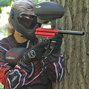paintball player in red valken paintball gear using red valken razorback paintball gun in action